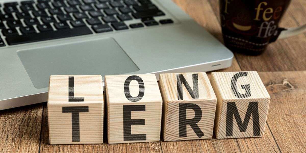 2 Long Term written on a wooden cube in a office desk