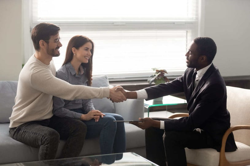 A man shaking hands with tenants, property management helping with tenant screening concept