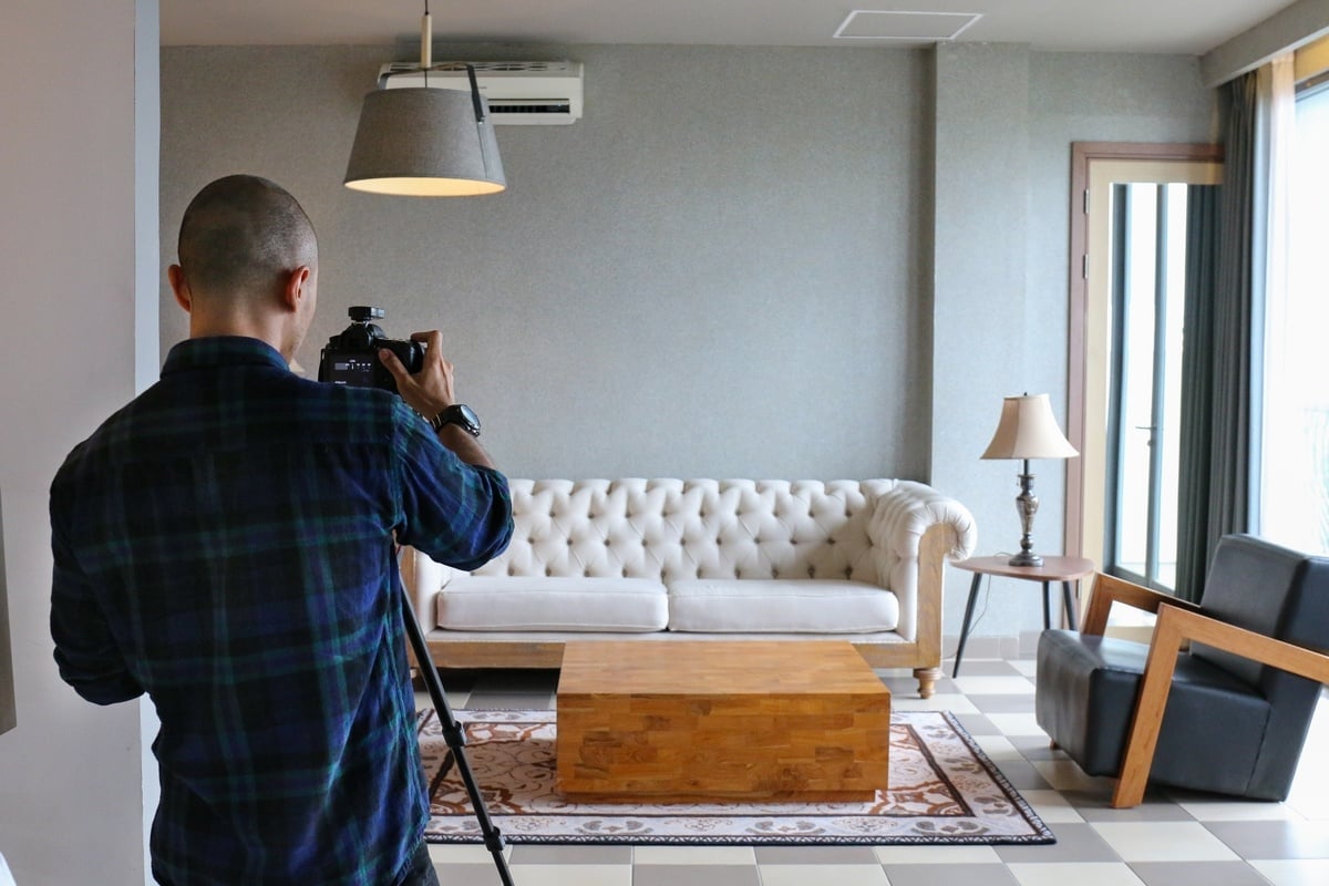 A professional photographer taking a photo of a living room