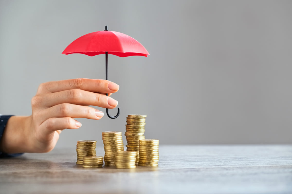 A small umbrella covering money, investment protection concept
