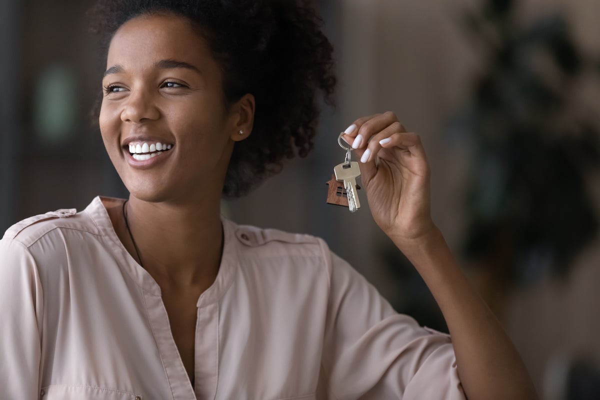 Happy tenant holding a key in her home