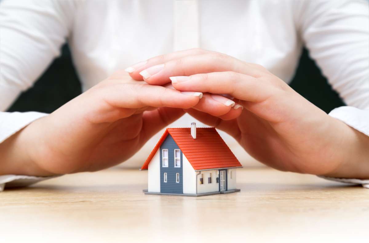 House covered of woman hands - insurance real estate concept