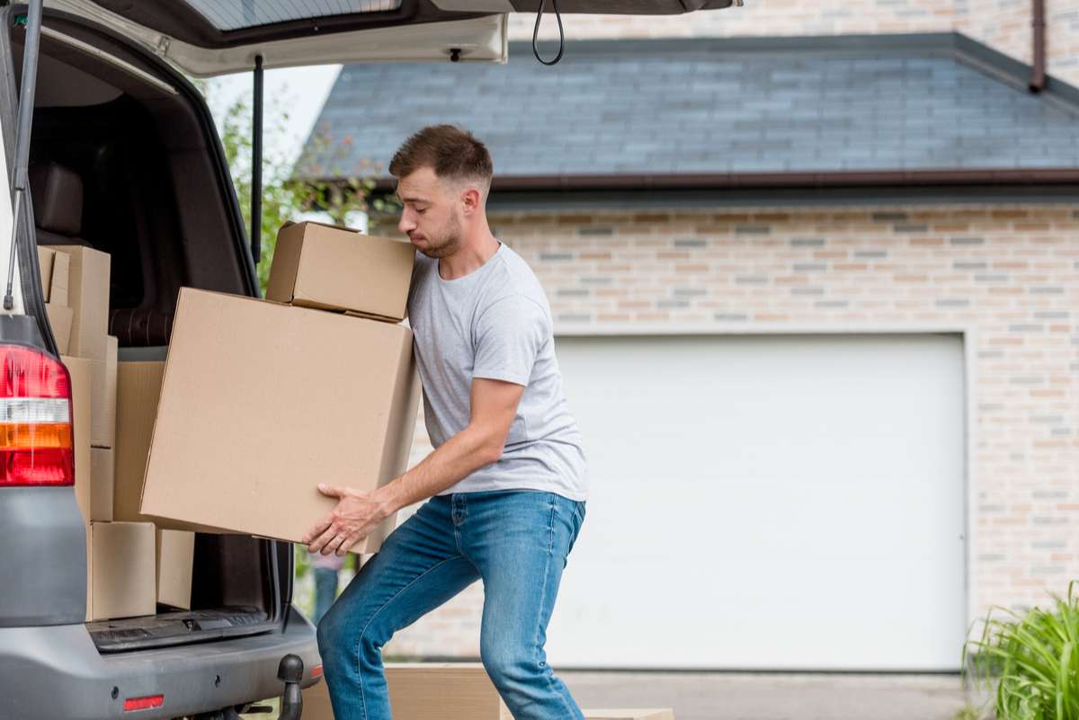 A man moving boxes into a car, Seattle property management concept. 