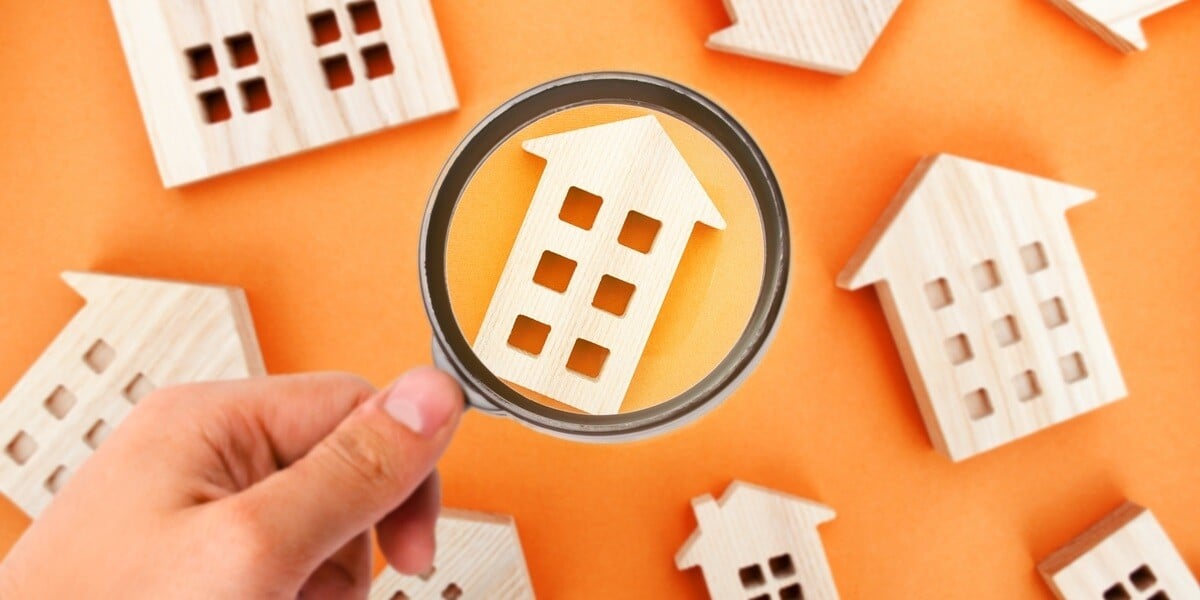 A magnifying glass on a wooden miniature home