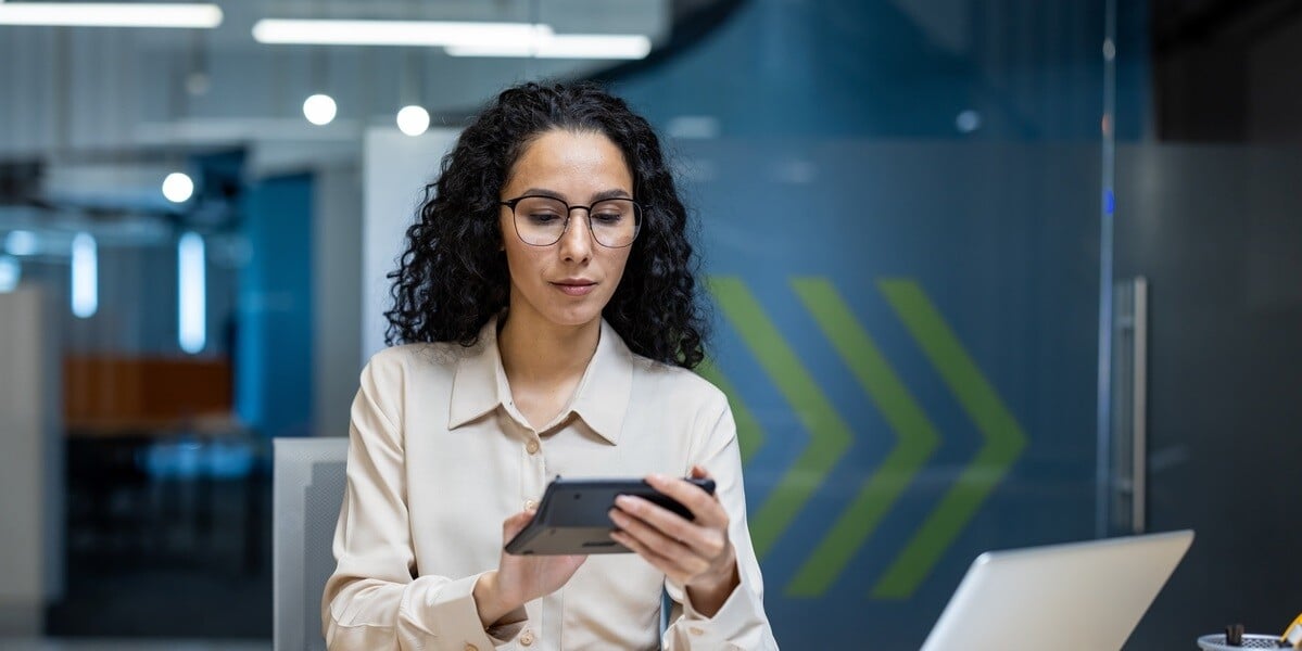 woman engaged in detailed financial analysis, holding calculator in hands